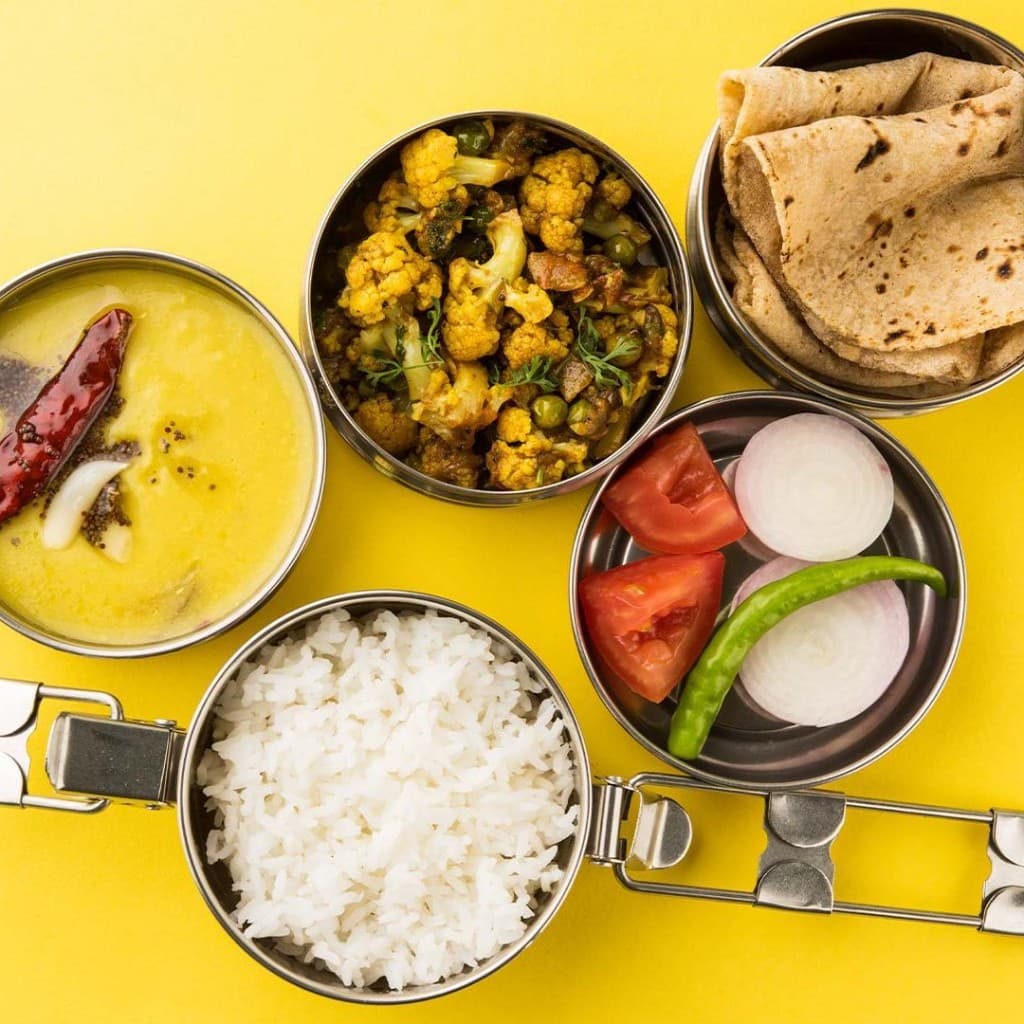 Home-style Indian thali — sabzi, dal, rice, bread, and salad